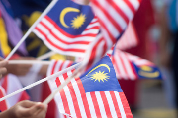 Naklejka premium Hand waving Malaysia flag also known as Jalur Gemilang in conjunction with the Independence Day celebration or Merdeka Day.