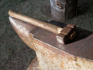 A hammer lying on the anvil. Smithy background