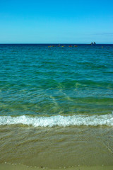 Fototapeta na wymiar Sunny sandy beach vacation, landscape with clear blue sea shore and sandy beach