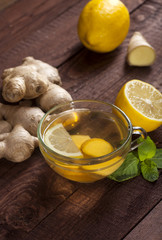Ginger tea with lemon, mint and honey on wooden background