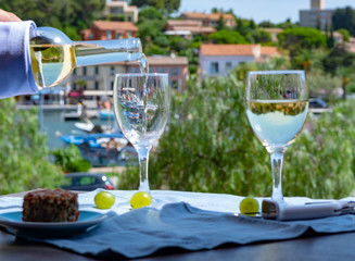 White wine of Provence, France, served cold with soft goat cheese on outdoor terrace in two wine glasses
