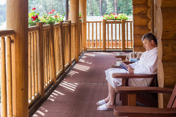 mature men with book on wooden terrace