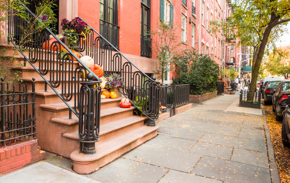 Pumpkins, flowers, and Halloween decorations on steps in West Village, New York