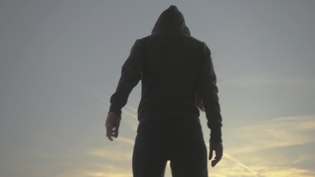 silhoutte of young hip hop girl with hoody performs experimental and freestyle moves