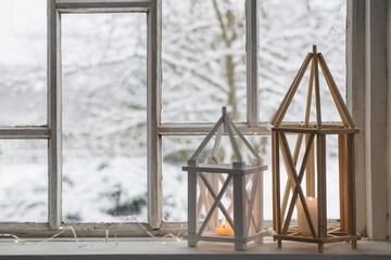 Obraz premium wooden lantern on windowsill on background winter landscape