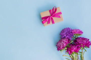 Bouquet with pink flowers with gift box on blue background