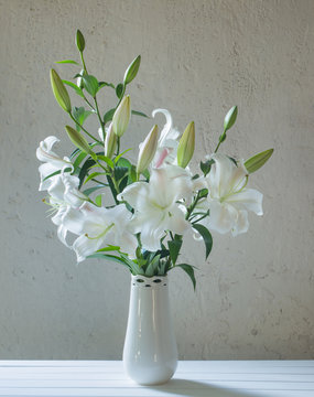 Fototapeta beautiful white lily in vase on background old wall
