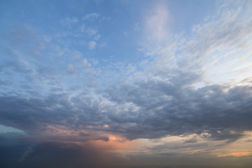 Obraz premium Panorama niebo przy wschodem słońca lub zmierzchem. Piękny widok ciemnoniebieskie chmury oświetlone przez jasne pomarańczowe słońce na jasnym niebie. Piękno i siła natury, meteorologia i koncepcja zmiany klimatu.