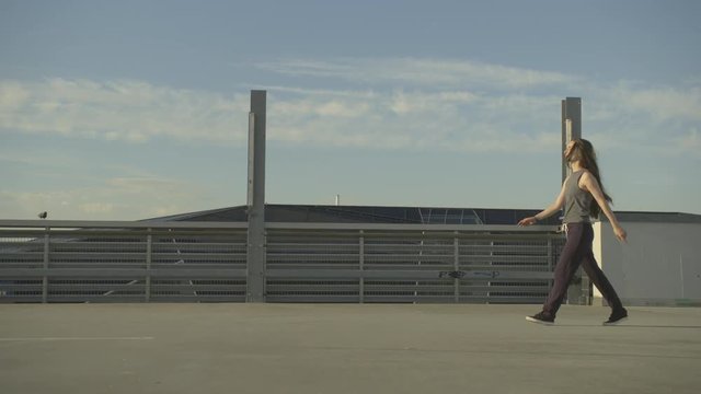 Hip hop girl performs a pirouettes on a concrete floor