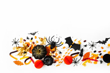 Halloween holiday background with colorful candy, bats, spiders, pumpkins and decorations. Flat lay. View from above