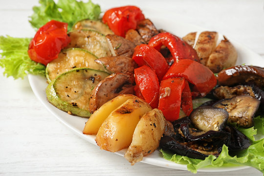 Plate with tasty grilled vegetables on table, closeup