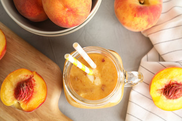 Tasty peach smoothie in mason jar on table, top view