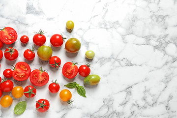 Flat lay composition with juicy tomatoes and space for text on marble background