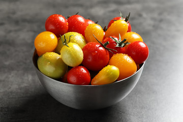 Bowl with tasty juicy tomatoes on table