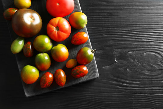Flat lay composition with juicy tomatoes and space for text on wooden background