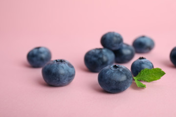 Tasty ripe blueberry on color background, closeup