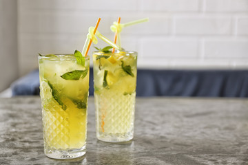 Glasses of iced lemonade on table indoors