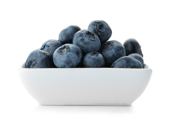 Bowl full of fresh ripe blueberries on white background