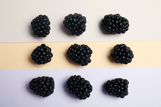 Flat lay composition with ripe blackberries on color background