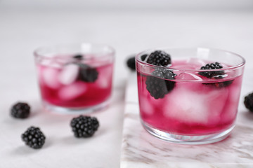 Glasses with iced blackberry lemonade on table