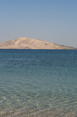 Croazia: l'acqua cristallina di Rucica, la spiaggia di ciottoli in una baia brulla circondata da un paesaggio desertico a sudest del villaggio di Metajna, sull'isola di Pago