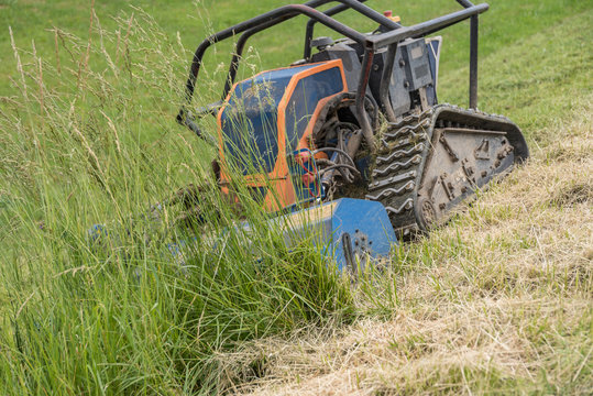 Robot mows meadow on hillside