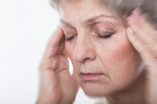 Seniorin woman with gray hair headache pain