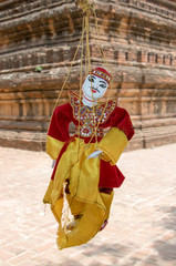 Obraz premium Traditional Myanmar puppet hangs on rope on tree in area Buddhist temple.