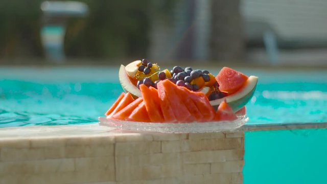 A fruit plate next to a private pool