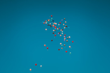 Baloons of different colors flying high in the sky