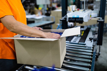 Close up shot of worker's hand preparing carton for printing in a modern printing house.
