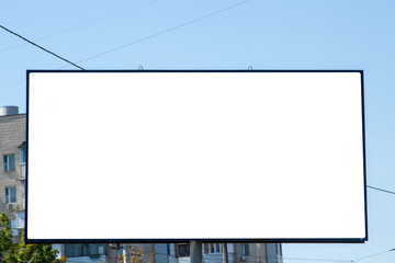 White billboard on the background of a residential high-rise building. Outdoor advertising in a residential area. Empty white canvas bigboard with space for text. Big billboard in the city landscape.