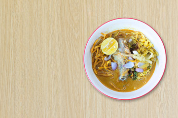 Noodle (Khao-Soi) with coconut milk,chicken ,lemon,pickles thai food style on wooden background,food style Northern Thailand