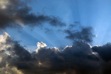 rays of the sun making their way through the clouds against the backdrop of the peaks of the mountains