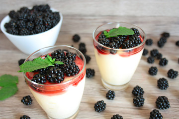 Fototapeta na wymiar Dessert with blackberries, vanilla cream and a mint leaf