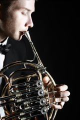 French horn player. Hornist playing brass instrument