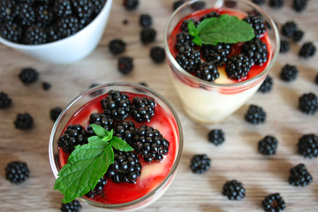 Dessert with blackberries, vanilla cream and a mint leaf