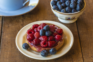 Beautiful cake with raspberries and blackberries on vintage wooden background