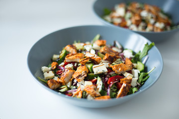 A healthy chicken salad in a grey bowl.