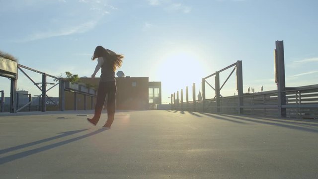 Hip Hop girl jumping around and dancing  with lens flare 