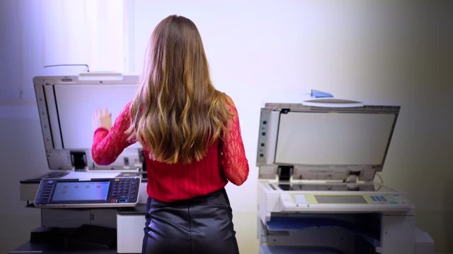 Busy secretaty female making document copies in office. Businesswonam using scanner for finance photocopy in company. Shot in 4K (UHD).