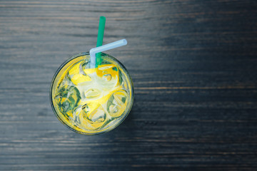 Lemonade with ice. Background wooden table. top view