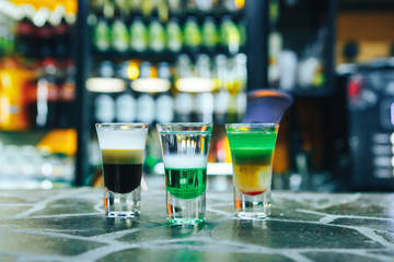 Multi-layered burning cocktail on bar.  Alcoholic short cocktails on the bar
