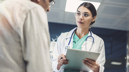 Health worker taking notes from male patient