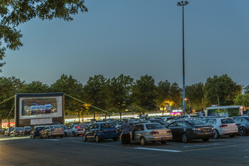 city parking with an inflatable screen of a summer cinema, waiting for a movie