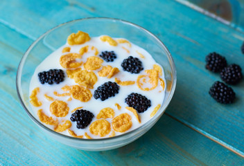Breakfast with milk, cereals and blackberries