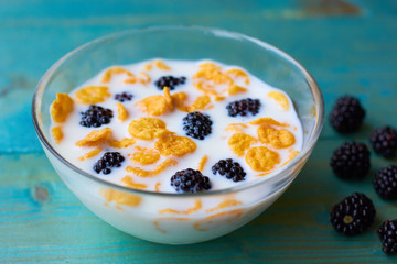Breakfast with milk, cereals and blackberries