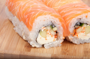 tasty sushi roll on the wooden board background