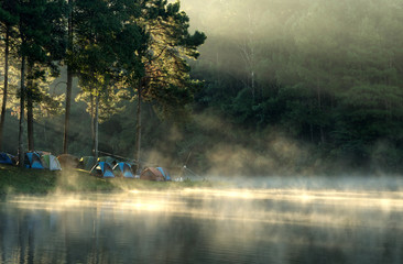 Dome tents beside the lake in the mist at sunrise at Pang Ung (Pang Tong reservoir), Mae Hong Son province, Thailand