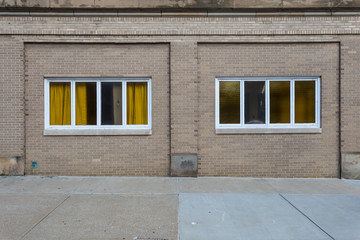 Yellow curtains in windows of brick building